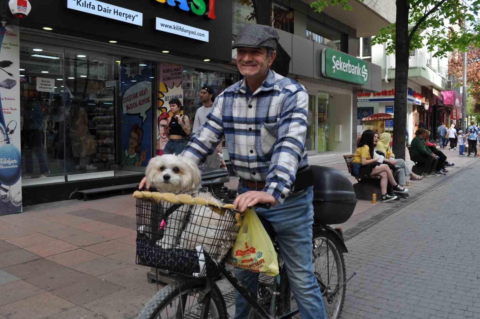 Köpeğini bisikletinin sepetine koyup güzel havanın tadını çıkardı