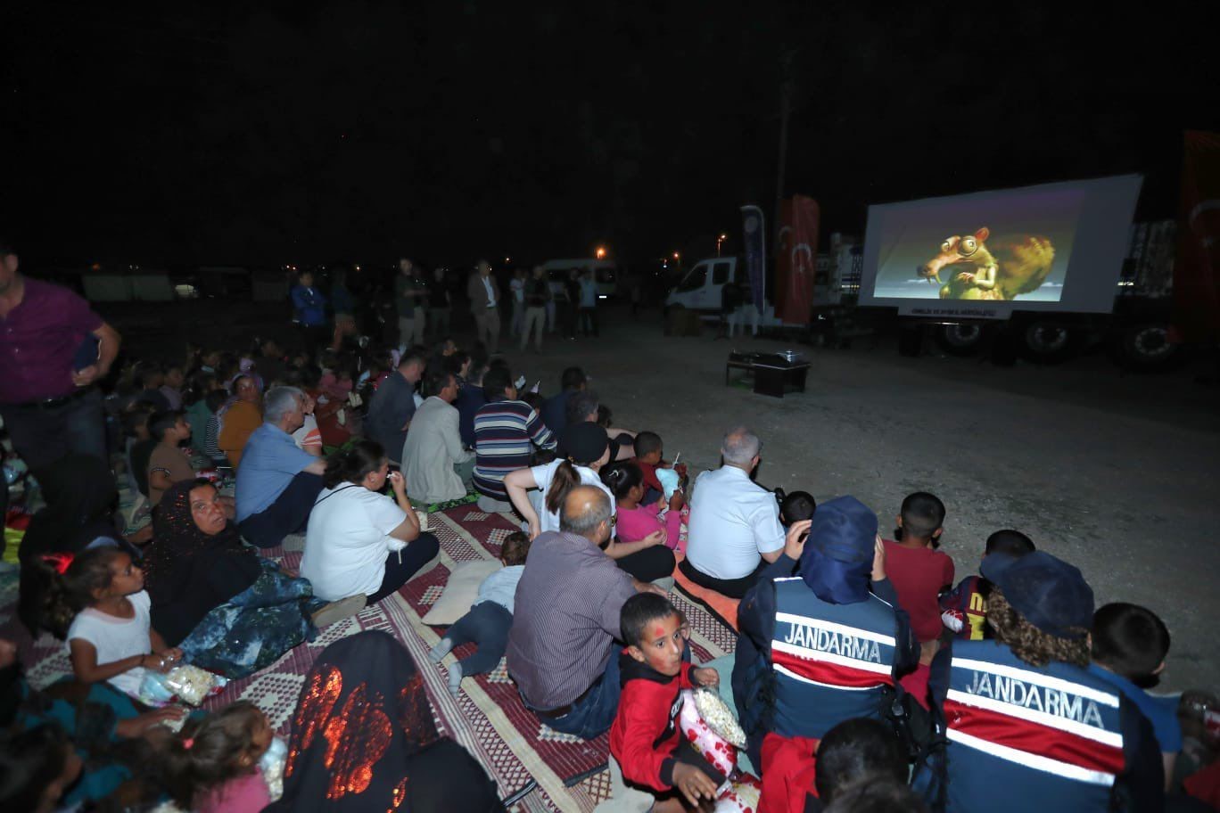 Vali Aksoy eşiyle yerde bağdaş kurup mevsimlik işçilerin çocuklarıyla film izledi