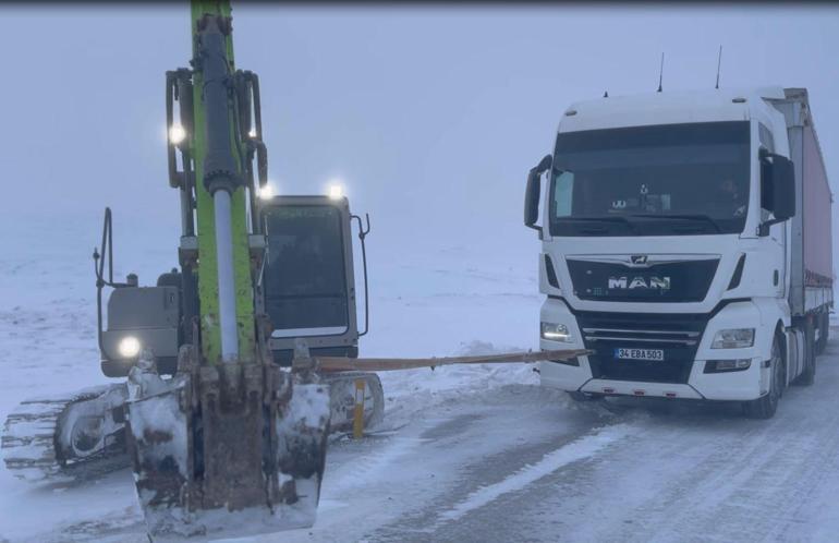 Kar nedeniyle yolda kalan TIR'a iş makineli kurtarma